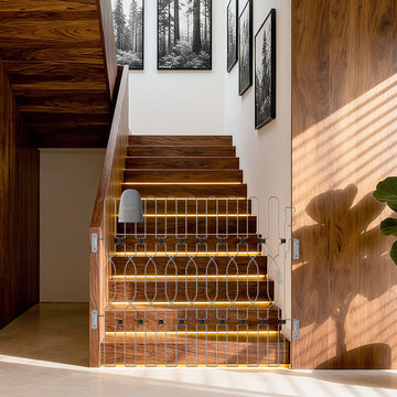 Snagle Paw Metal Retractable Door Barrier fully expanded and installed at the stairs, acting as a secure dog gate for stairs. The sturdy metal design functions as a retractable dog gate and reliable indoor dog gate, helping prevent pets from accessing the staircase while maintaining a clean, modern look.